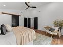 Spacious primary bedroom featuring hardwood floors, a ceiling fan, and a decorative sliding barn door at 4562 Rockford Ct, Charlotte, NC 28209