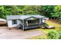 Inviting single-story home with a covered porch, black railings, and natural landscape at 51 Emily Ln, Taylorsville, NC 28681
