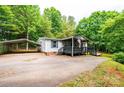 Inviting single Gathering home featuring a covered porch, American flag, carport and wooded surroundings at 51 Emily Ln, Taylorsville, NC 28681