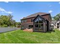 A spacious backyard with a patio and full glass wall with an architectural design at 5432 Carmel Rd, Charlotte, NC 28210