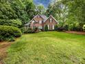 Beautiful two-story brick home surrounded by mature trees and a well-maintained lawn at 5816 Valley Stream Trl, Waxhaw, NC 28173