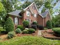Inviting brick home with manicured landscaping, stone pathway, and lush green lawn at 5816 Valley Stream Trl, Waxhaw, NC 28173