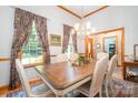 Elegant dining room featuring a large table, six chairs, chandelier lighting, and natural light at 7545 Rabbit Cir, Denver, NC 28037