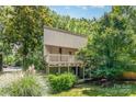 Two-story townhouse with a private balcony surrounded by lush trees, offering a serene outdoor living space at 7900 Horse Chestnut Ln, Charlotte, NC 28277