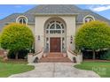 Grand front entrance featuring a symmetrical design, stone walkway, and mature landscaping at 8800 Covey Rise Ct, Charlotte, NC 28226