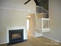Cozy living room with fireplace, staircase, ceiling fan, and neutral carpet at 9139 Charminster Ct, Charlotte, NC 28269