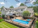 Backyard oasis with a sparkling pool, spa, outdoor kitchen, and a spacious patio perfect for entertaining at 9202 Arlington Hills Dr, Mint Hill, NC 28227
