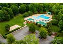 Overhead view of a community pool with a water slide, lounge chairs, and verdant landscaping at 9410 Greenbank Ct, Charlotte, NC 28214