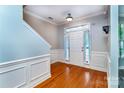 Inviting foyer with hardwood floors, wainscoting, and a staircase leading to the upper level at 9410 Greenbank Ct, Charlotte, NC 28214