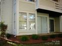 An exterior view of a condo, featuring horizontal siding, multiple windows, and a well-kept lawn at 9603 Vinca Cir # A, Charlotte, NC 28213