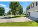 View of the property's manicured front lawn and driveway leading to the attached garage, showcasing its curb appeal at 1005 Exodus Ct, Monroe, NC 28110