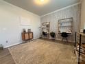 A room featuring stylish wallpaper, two desks, and a cozy rug, creating a functional workspace at 1016 Laggan Ln, Indian Trail, NC 28079