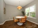 Cozy dining room featuring a round table, stylish chairs, modern light fixture, and natural light at 10639 Secret Garden Ln, Charlotte, NC 28214