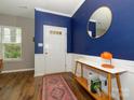 Inviting foyer featuring hardwood floors, wainscoting, a stylish mirror, and a modern console table at 10639 Secret Garden Ln, Charlotte, NC 28214