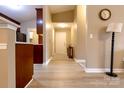 Bright hallway featuring wood-look floors, neutral walls, and a view to the front door and kitchen at 11867 Ridgeway Park Dr, Charlotte, NC 28277