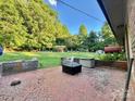 Outdoor patio area with a brick surface and outdoor furnishings, surrounded by greenery at 1229 Rocky Face Church Rd, Taylorsville, NC 28681