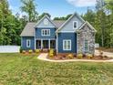 Charming two-story home showcasing blue siding, stone accents, and manicured landscaping at 1622 Hunters Place Rd, York, SC 29745
