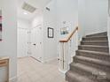 Bright foyer with tile flooring, staircase, coat closet, and horseshoe decor creating a welcoming entrance at 17732 Kings Point Dr, Cornelius, NC 28031