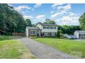 Charming two-story home featuring a long driveway, lush lawn, and classic architectural style at 205 Wingate Dr, Stanley, NC 28164