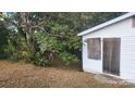 Exterior shot of a small, weathered home with boarded up windows and overgrown foliage at 210 Mahan Sw St, Concord, NC 28025