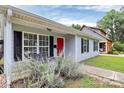 Cozy front porch featuring outdoor seating, a bright red door, and charming black shutters at 2117 Yadkin Ave, Charlotte, NC 28205