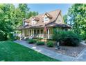 Beautifully landscaped home with a wrap-around porch, complemented by lush greenery at 2168 Sunset Cir, Fort Mill, SC 29715