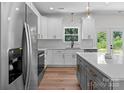 Modern kitchen with quartz countertops, stainless steel appliances, hardwood floors and gray kitchen island at 2220 Mooresville Rd, Salisbury, NC 28147