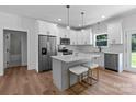 Bright kitchen features white cabinetry, stainless appliances, large island with seating, and modern pendant lighting at 2220 Mooresville Rd, Salisbury, NC 28147