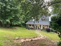 Inviting home exterior featuring a charming front porch, lush lawn, and landscaped walkway at 223 Tennessee Trl, Lincolnton, NC 28092