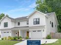 A modern farmhouse with white siding, a garage, and a 10 x 18 concrete pad added for convenience at 2517 Marlowe Ave, Charlotte, NC 28208