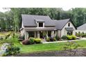Charming two-story home with landscaped yard, covered porch and modern farmhouse details on a lush green lawn at 2656 Lee Lawing Rd, Lincolnton, NC 28092