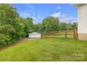 Spacious backyard featuring a fenced yard, storage shed, and bordered by mature trees at 350 Moose Dr, Stony Point, NC 28678