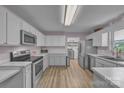 Bright kitchen featuring stainless steel appliances, white cabinets, and a window over the sink at 350 Moose Dr, Stony Point, NC 28678