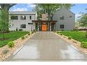 Modern home featuring a concrete driveway, orange front door, and well-maintained landscaping at 3822 Topsfield Rd, Charlotte, NC 28211