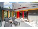 Outdoor patio featuring lounge chairs and access to the modern home's interior through glass doors at 386 Squirrel Ln, Lake Wylie, SC 29710