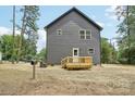 Rear view of home featuring a small wooden deck and partial fencing at 401 W Charlotte Ave, Mount Holly, NC 28120