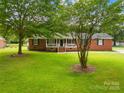 Quaint brick house with a covered front porch and a sprawling green lawn at 815 Lakeside Cir, Lancaster, SC 29720