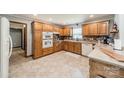 Well-lit kitchen with oak cabinets, white appliances, and ample counter space for culinary enthusiasts at 8698 Rocky River Rd, Harrisburg, NC 28075