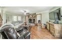 Inviting living room with stone fireplace, ceiling fan, and access to the outdoors, perfect for relaxation at 8698 Rocky River Rd, Harrisburg, NC 28075