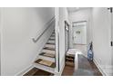 Light-filled entryway showcasing a staircase and practical storage with a bench and shoe rack at 919 Cityscape Dr, Charlotte, NC 28205