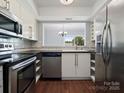 Modern kitchen with stainless steel appliances, sleek countertops, and wood-look flooring at 9404 S Vicksburg Park Ct, Charlotte, NC 28210