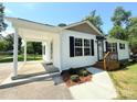 Side view of a cozy home with a covered carport and a well-manicured walkway leading to the front entrance at 111 W Perry St, Heath Springs, SC 29058