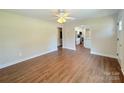 Bright living room featuring wood floors that flow into a kitchen with white cabinetry and a kitchen island at 111 W Perry St, Heath Springs, SC 29058