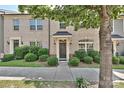 Inviting brick townhome featuring tidy shrubs and a welcoming front entrance at 1329 Jacemans Way, Cornelius, NC 28031