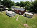 Aerial view of backyard featuring outbuildings, level lawn, and mature trees at 1585 Salem Church Rd, Lincolnton, NC 28092