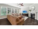 Cozy living room featuring hardwood floors, a fireplace, and large windows at 1805 Sutter Creek Dr, Waxhaw, NC 28173