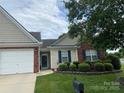 Charming single-story home boasts manicured lawn, brick accents, and attached garage for comfortable suburban living at 204 Woodbridge Cir, Mount Holly, NC 28120
