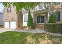 Inviting brick home entrance with double doors, manicured landscaping, and a two-car garage at 4392 Sunset Rose Dr, Fort Mill, SC 29708