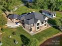 Aerial view of a house with a large, well-manicured lawn, surrounded by lush greenery and mature trees at 445 Sundown Rd, Mooresville, NC 28117