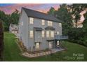 Beautiful back exterior with large windows, deck, patio, and landscaped yard, perfect for outdoor living at 5021 Meadow Woods Dr, Lowell, NC 28098